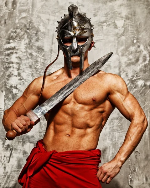 Гладиатор с мускулистым телом с меч и шлем — стоковое фото