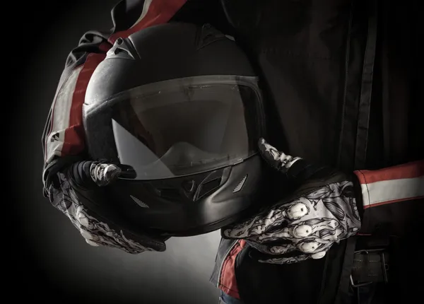 Мотоциклиста с шлемом в его руках. Темный фон — стоковое фото