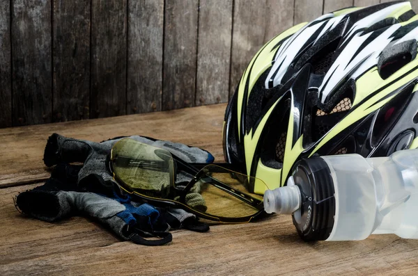 Шлем, перчатки и бутылка воды - велосипедные аксессуары на деревянный стол — стоковое фото