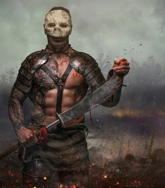 Мужчина в маске черепа держит меч — стоковое фото