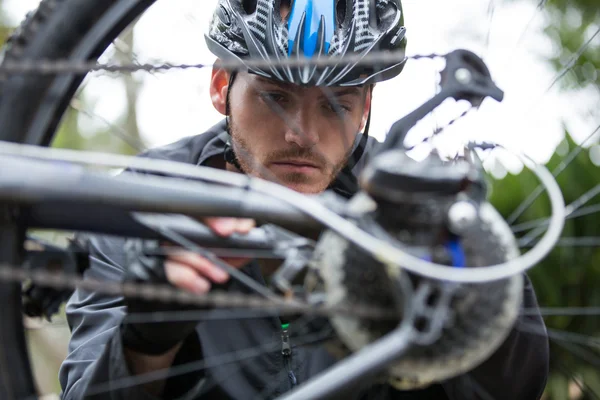 Мужской велосипедист, ремонт его горный велосипед — стоковое фото