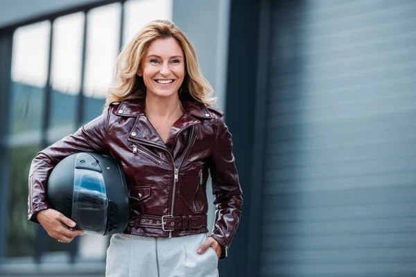 Smiling Woman Leather Jacket Holding Motorcycle Helmet Street Looking Away — стоковое фото