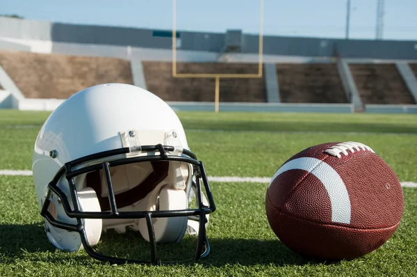 Американский футбол и шлем на поле Стоковое Фото
