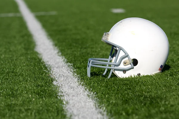 Американский футбол шлем на поле Стоковое Изображение
