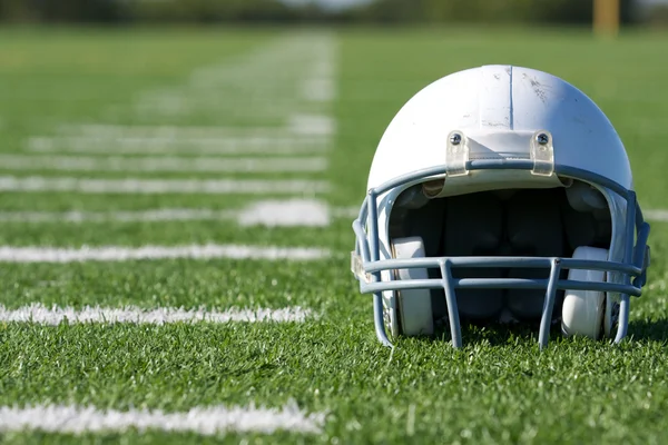 Американский футбол шлем на поле Стоковая Картинка