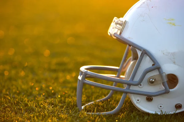 Американский футбол шлем на поле с подсветкой Лицензионные Стоковые Изображения